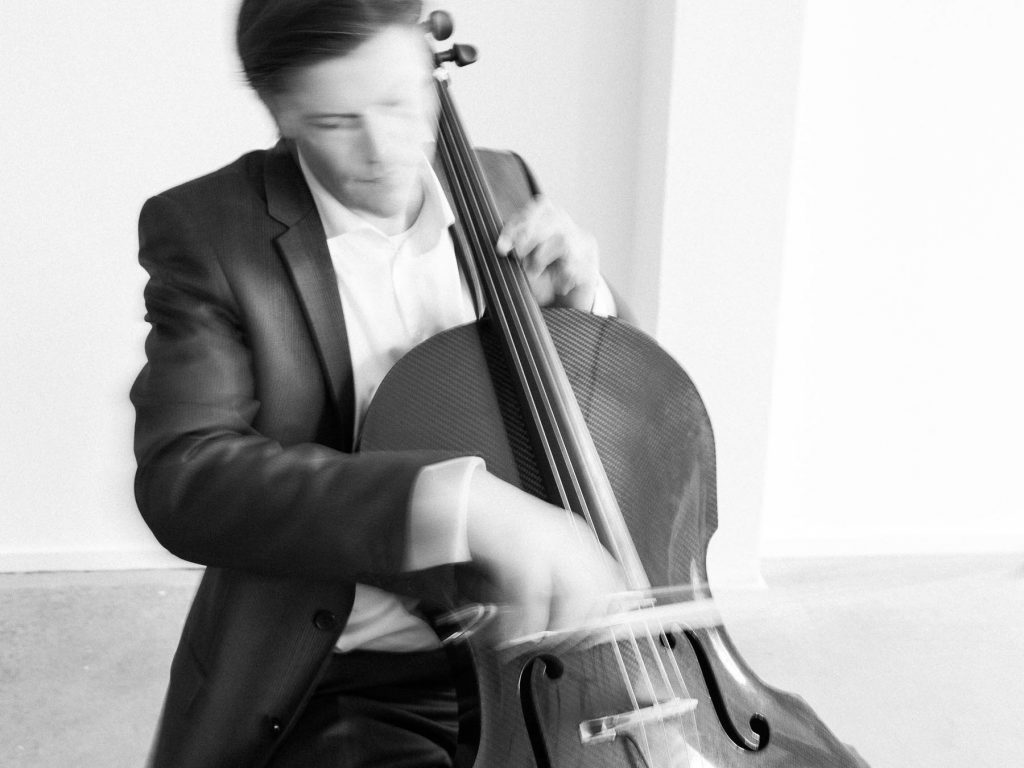 Ein Cello-Spieler spielt auf einer Hochzeit in Hamburg. Die Location ist urban und heißt ISLAND Hamburg.