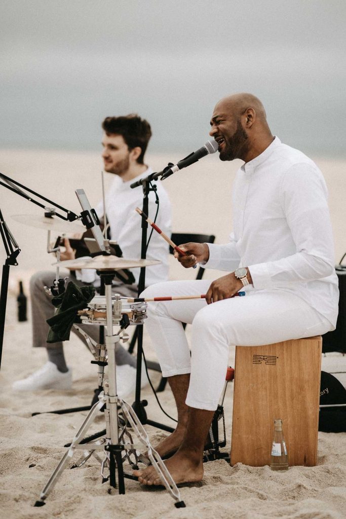 Heiraten mit Live Musik auf Sylt. Musiker mit Gitarre und Schlagzeug spielen am Strand.