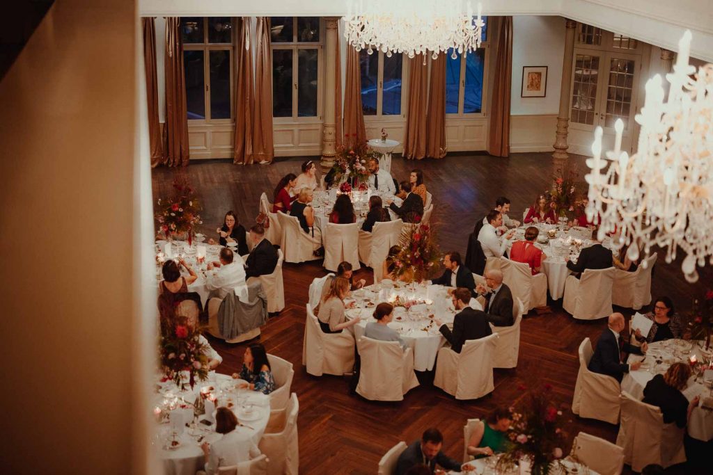 Eine Hochzeitsgesellschaft beim Dinner im Kristallsaal des Hotel Süllberg Hamburg.