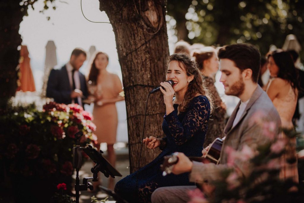 Eine Hochzeitsfeier im Hotel Süllberg in Hamburg. Auf der Terrasse spielt ein Duo mit Gesang und Gitarre Live Musik.