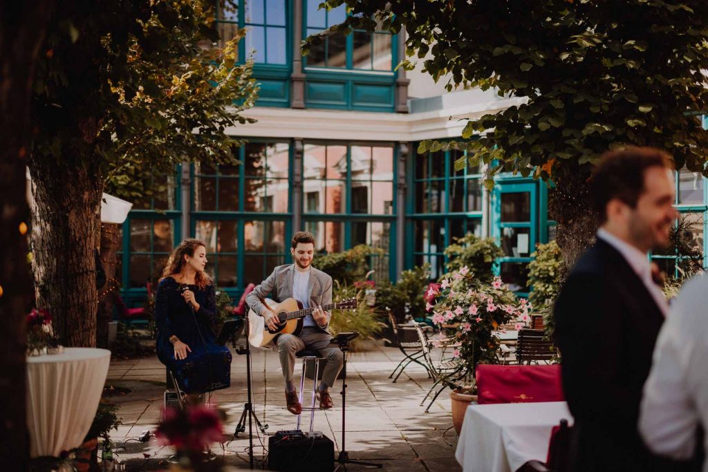 Eine Hochzeit im Süllberg Hamburg. Eine Band mit Gesang und Gitarre spielt Live Musik auf der Terrasse.