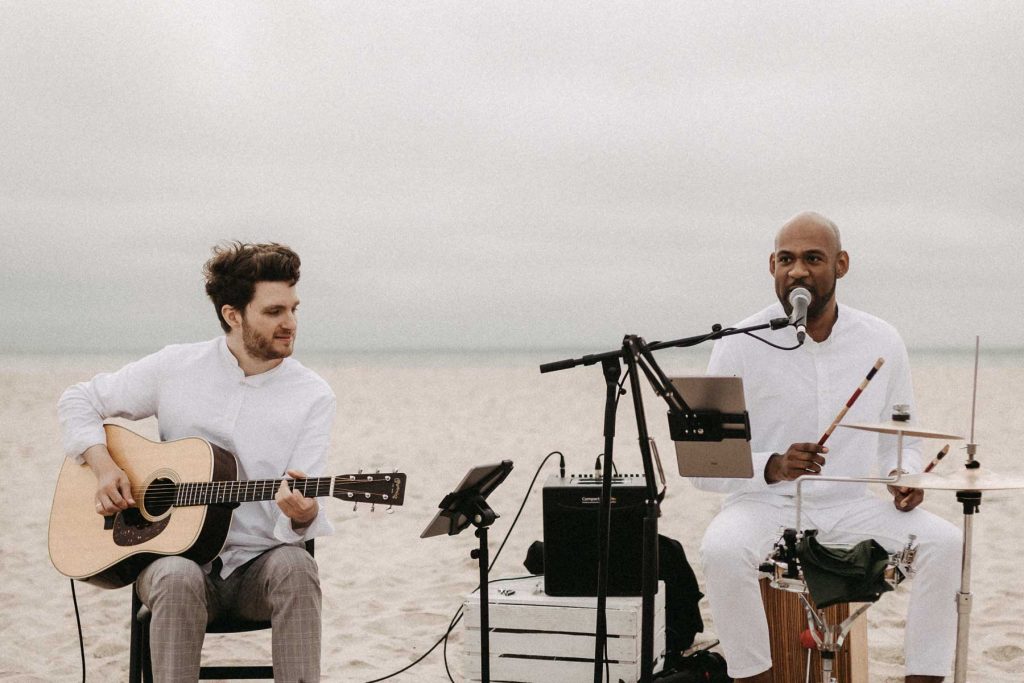 Live Musik zur Hochzeit auf Sylt. Zwei Musiker spielen am Strand.