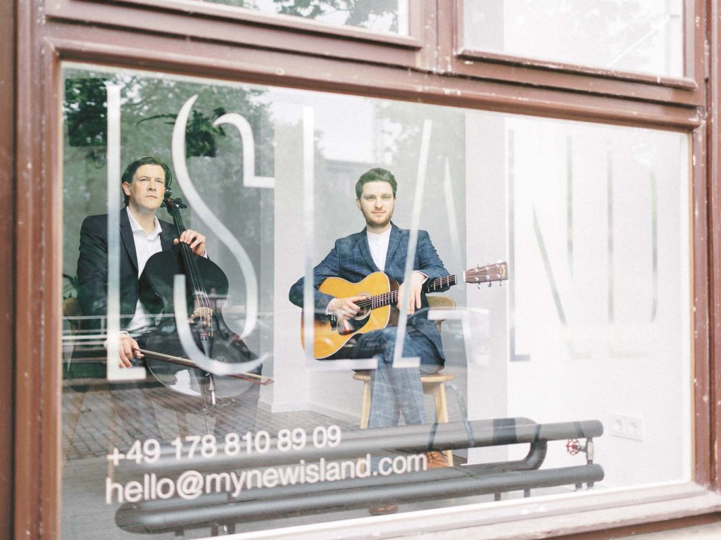Zwei Musiker hinter dem Fenster der urbanen Hochzeitslocation ISLAND in Hamburg.