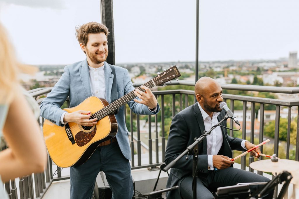 Musiker mit Gitarre, Schlagzeug und Gesang spielen auf der Dachterrasse zur Hochzeit in der Sturmfreien Bude Alster.