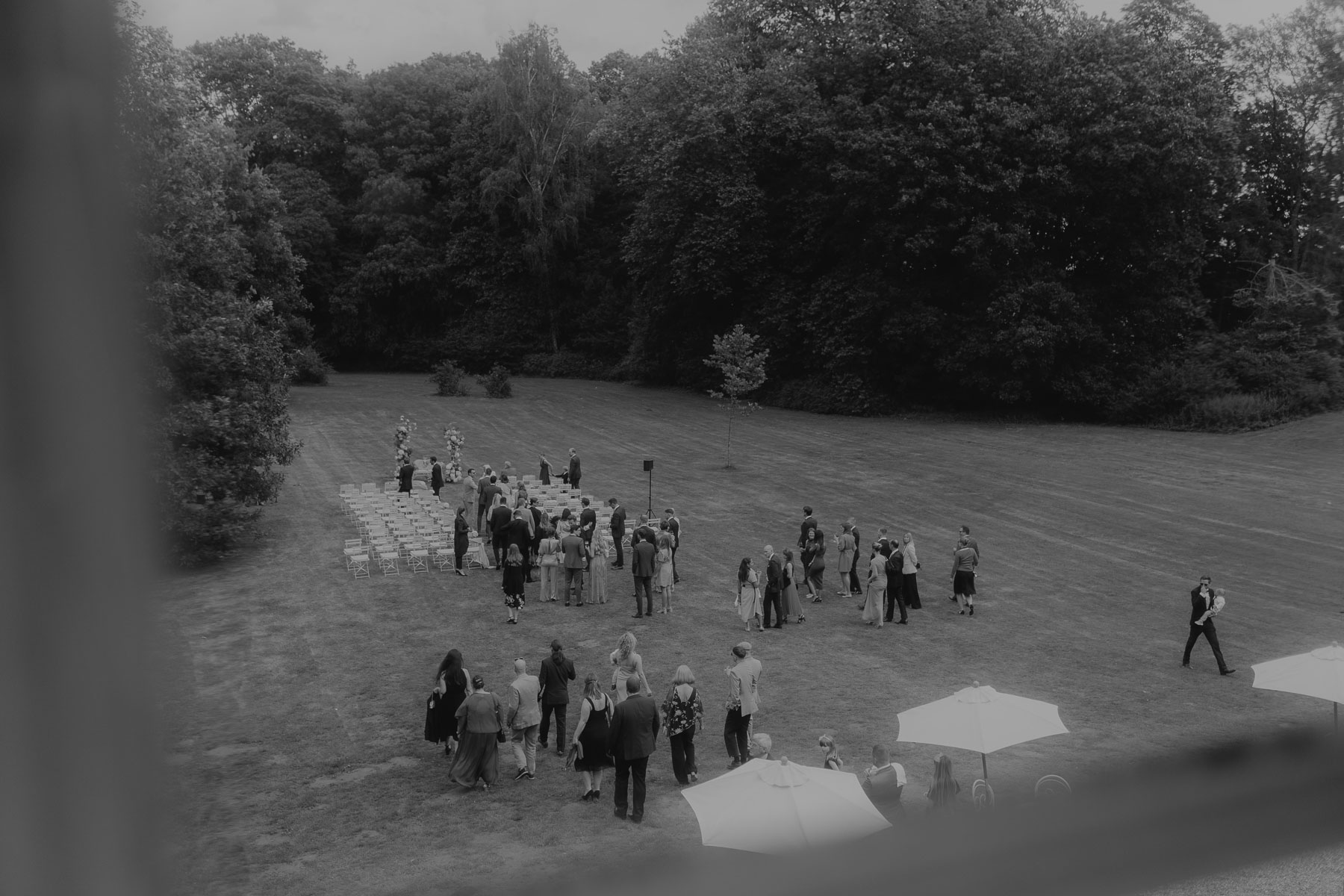 Ein Paar heiratet auf Gut Bliestorf. Die Gästen gehen zur Trauung in den Park.