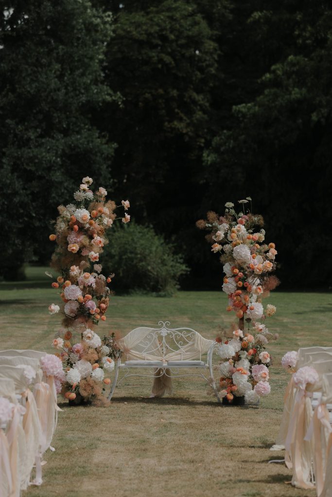 Eine Trauung auf Gut Bliestorf. Blumendekoration und Stühle auf der Wiese.