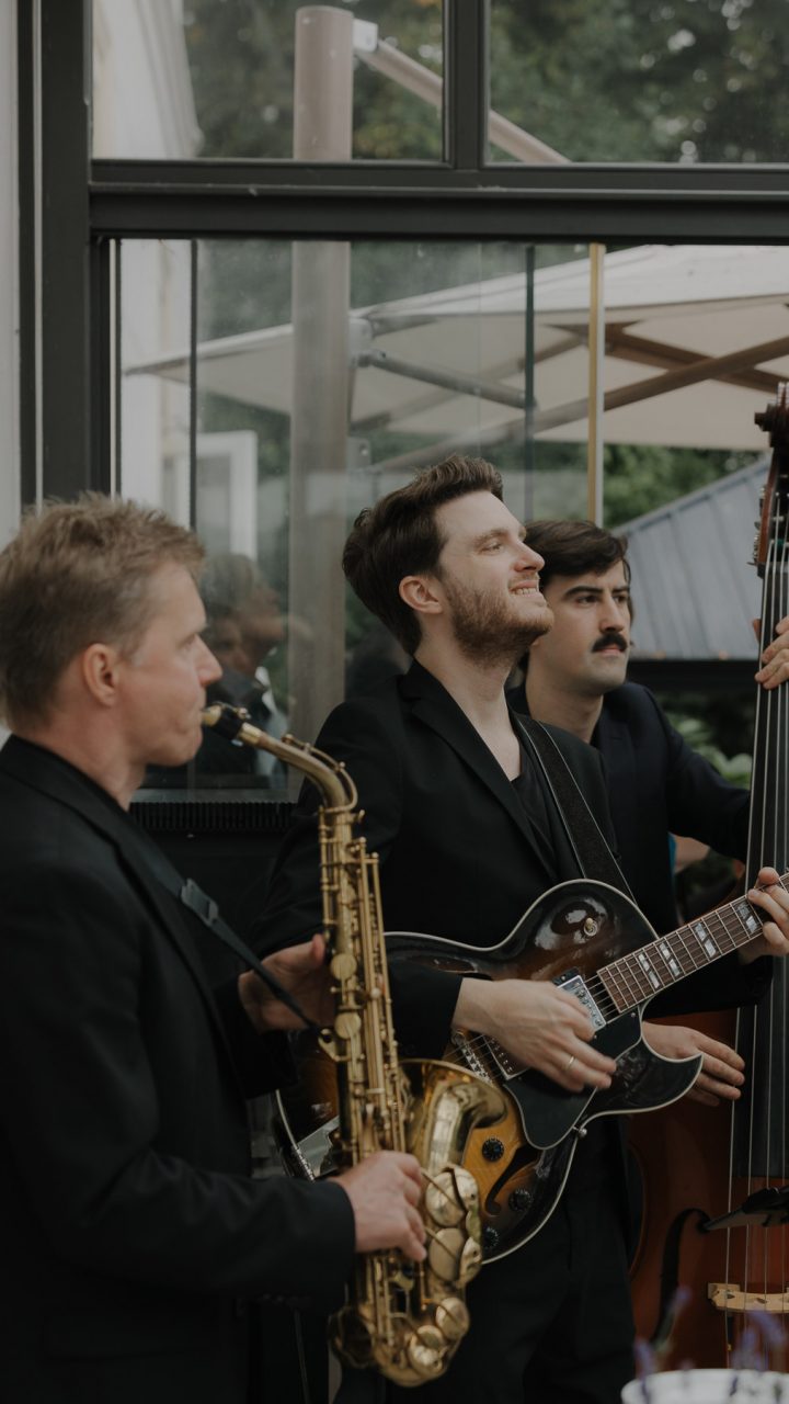 Musiker mit Saxofon, Gitarre und Kontrabass bei einer Hochzeit auf Gut Bliestorf.